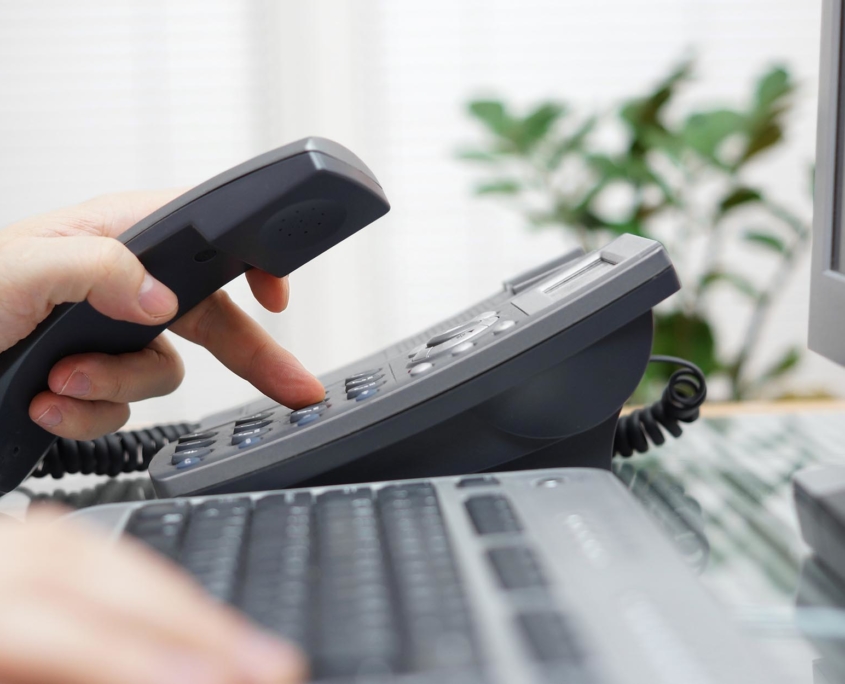Person dialing office phone using Business Phone Services