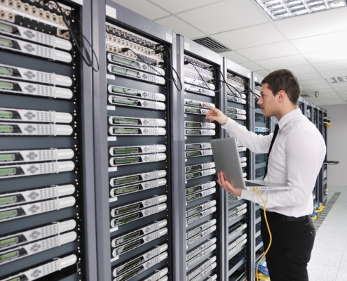 Image of a professional using a laptop in a data center.