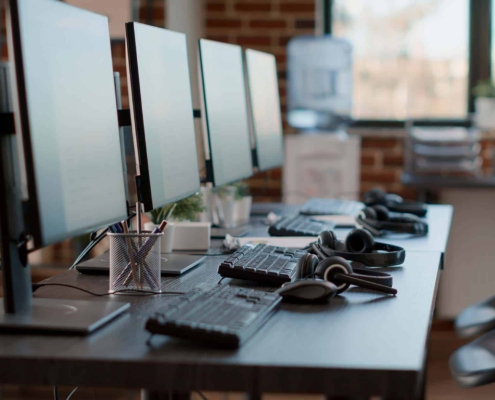 Empty customer service workstation to help telemarketing clients, modern call center technology for sales assistance and support. No people in office with monitors and_