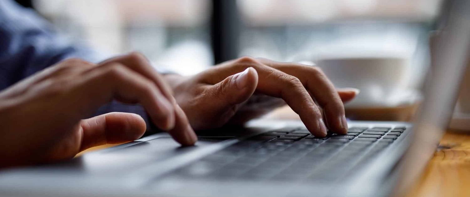 Side view of someone typing on a laptop